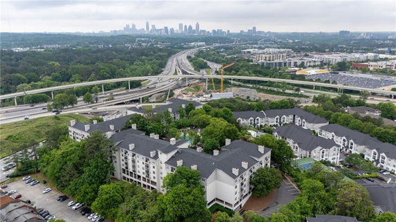 Panoramic view of residential buildings with highways and city skyline in the background.