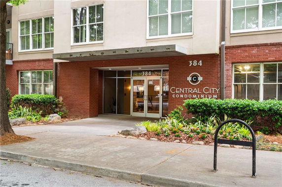 Front view of a condominium building with brick and stucco facade.