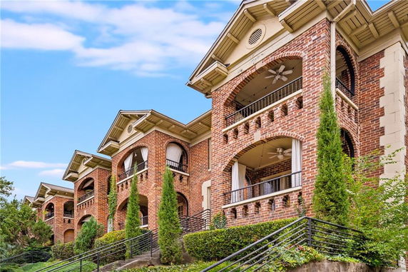 Front view of a multi-story brick building with arched balconies.
