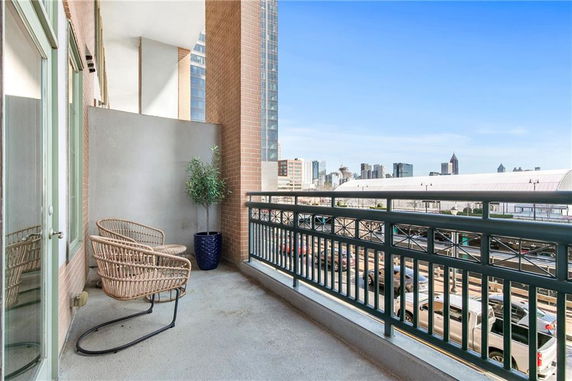Balcony view with seating overlooking a cityscape.