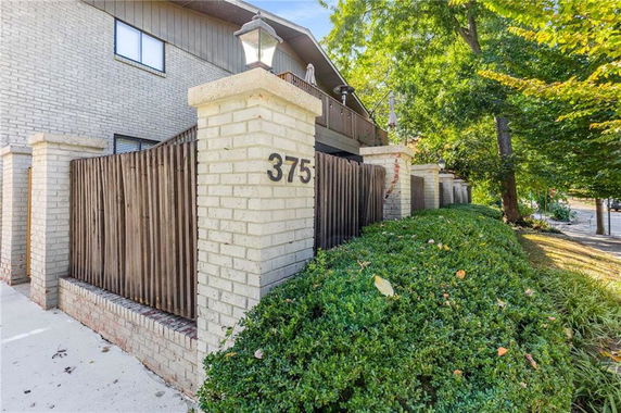 Front view of a building with brick pillars and wooden fencing.