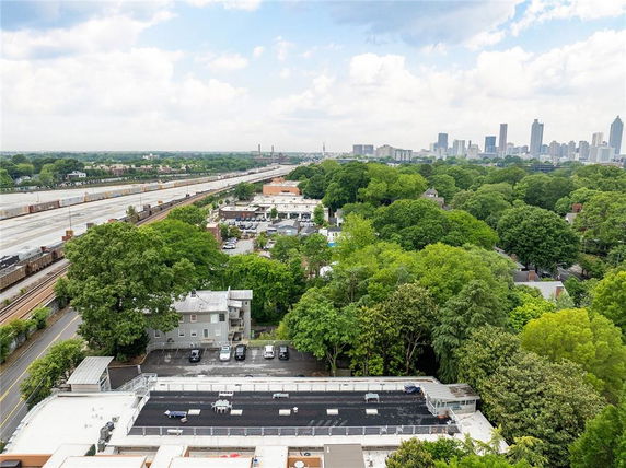 Panoramic view from a building overlooking a cityscape with trees and railway tracks.