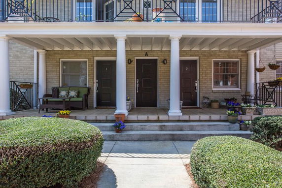 Front view of a two-story building with a covered porch and columns.