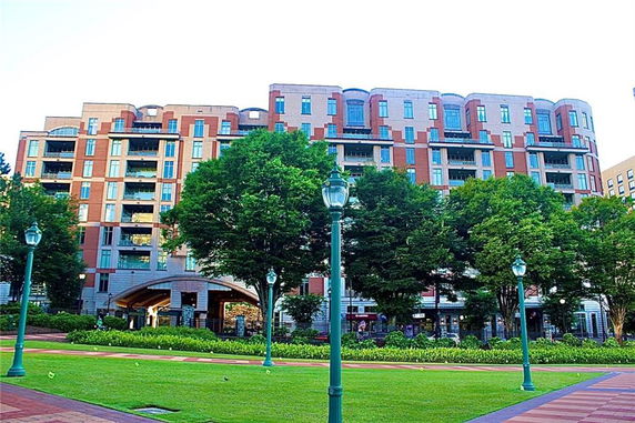 Front view of a multi-story residential building with balconies and a curved entryway.