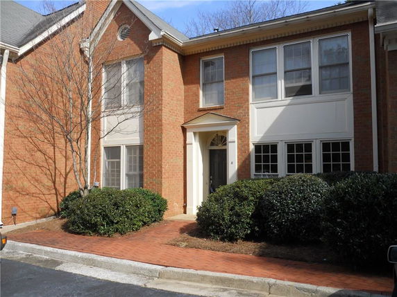 Front view of a two-story brick house with multiple windows.