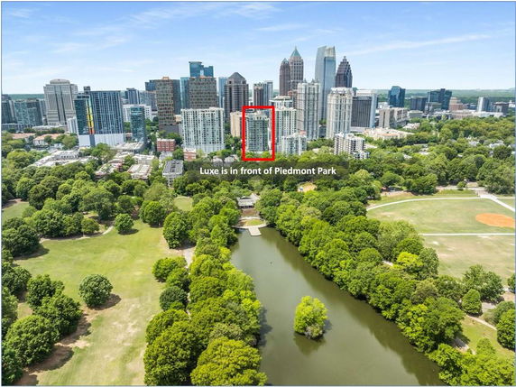 Panoramic view of a cityscape with skyscrapers and a park with a lake.