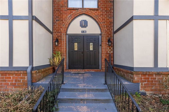 Front entrance of a building with brick and stucco facade.