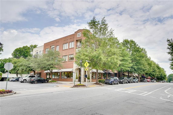 Front view of a multi-story brick building with parking area in front.