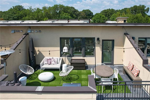 Rooftop patio with seating area and outdoor furniture.