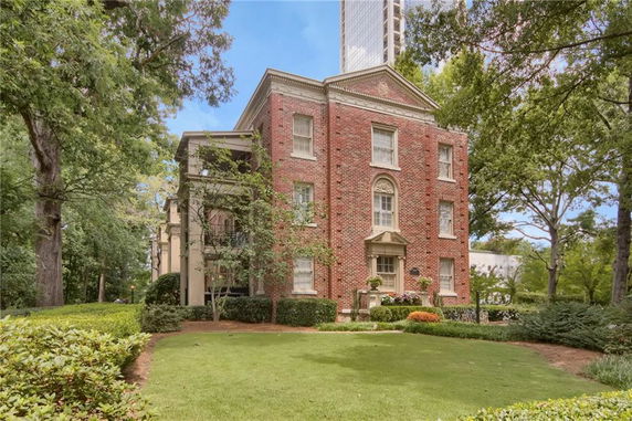 Front view of a multi-story brick house with classical architectural elements.