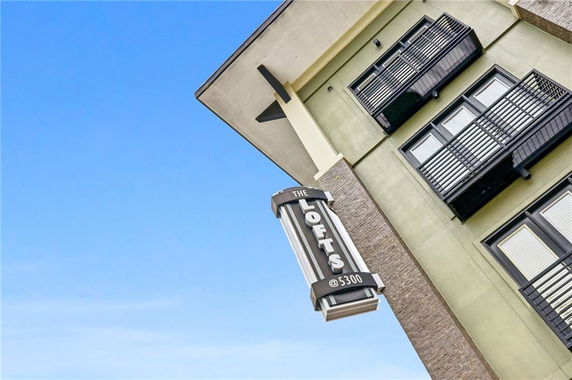 Angled view of a multi-story building with balconies and a sign reading 'The Lofts @ 5300.'