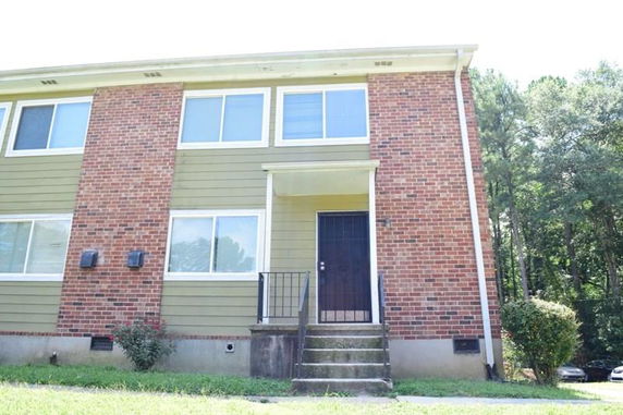 Front view of a two-story house with a combination of brick and siding exterior.