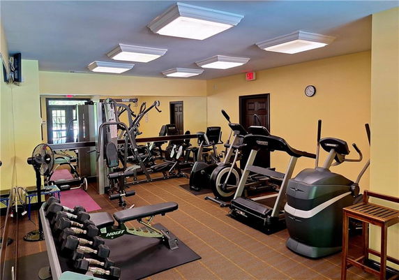 Indoor gym area with exercise equipment and mirrors.