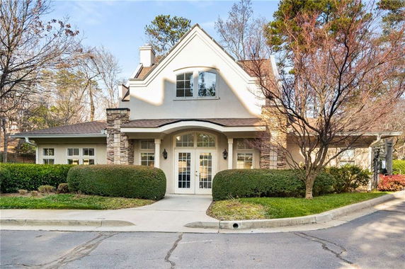 Front view of a two-story house with a prominent gable and stone accents.