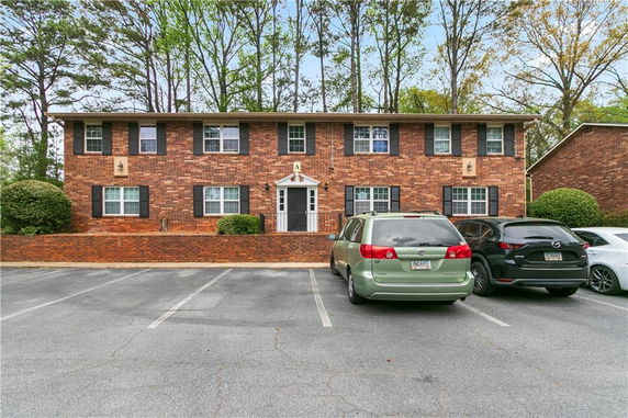 Front view of a two-story brick building with a flat roof and multiple windows.