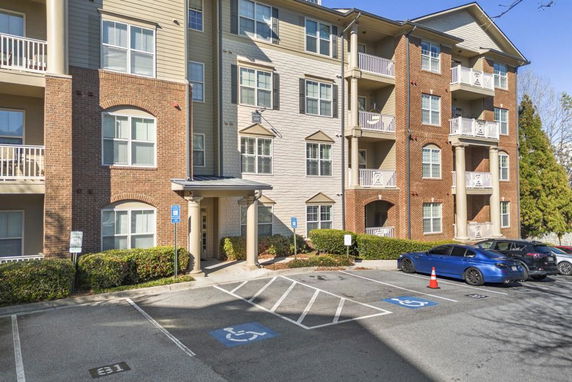 Front view of a multi-story apartment building with balconies.