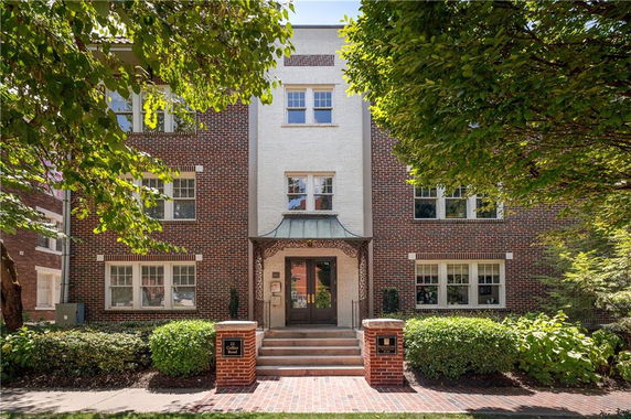 Front view of a multi-story brick building with a decorative entrance.