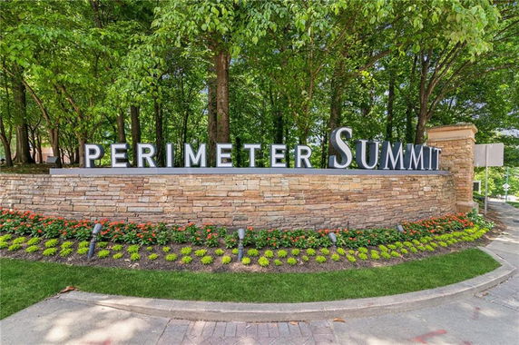 Front view of a stone wall sign with the text 'Perimeter Summit'.