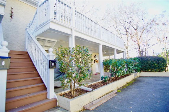 Front view of a house with an external staircase and a covered porch.
