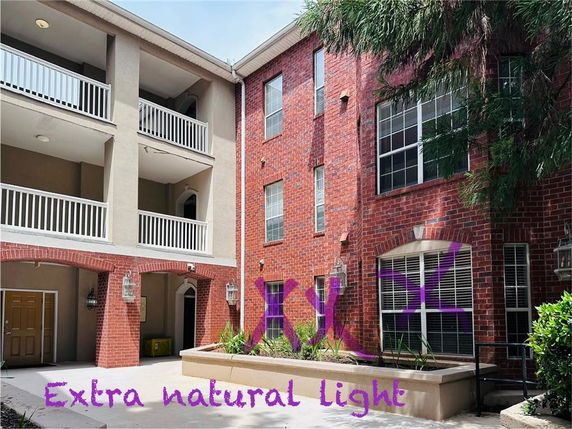 View of a multi-story building with brick exterior and balconies.