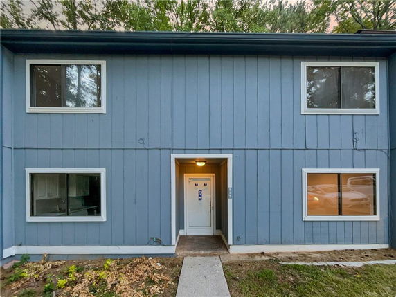 Front elevation of a two-story house with a blue exterior and several windows.