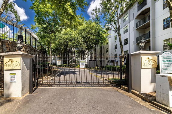 Front view of a multi-story condominium building with gated entrance.