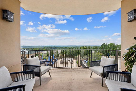 Balcony view overlooking a vast green landscape with distant city skyline.