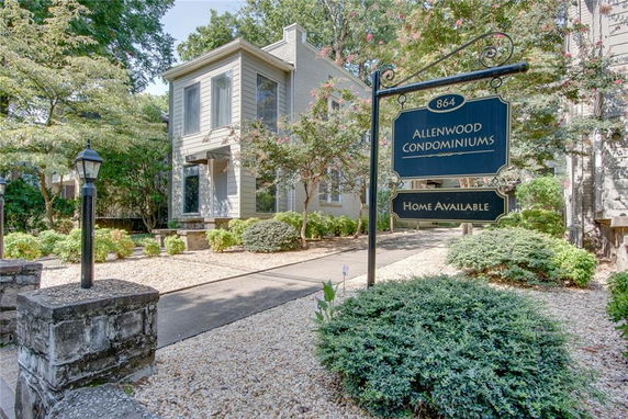 Front view of a condominium building with a 'Home Available' sign.
