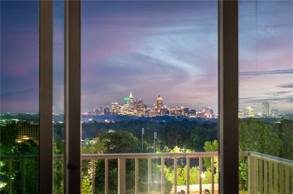 Panoramic view of a city skyline seen through large windows at dusk.