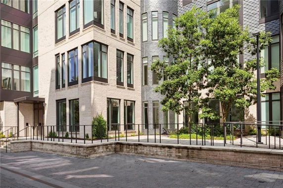 Front view of a multi-story building with large windows and a landscaped entrance.