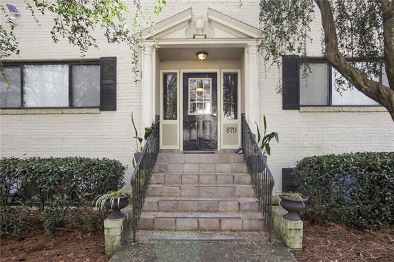Front view of a building entrance with steps and pillars.