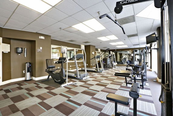 Indoor gym area with various exercise equipment and machines.