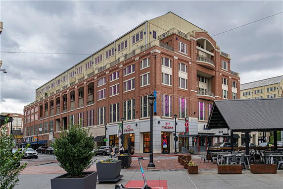 Front view of a multi-story commercial building with brick façade and large windows.