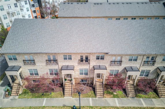Front view of a row of brick townhouses with steps leading to each entrance.