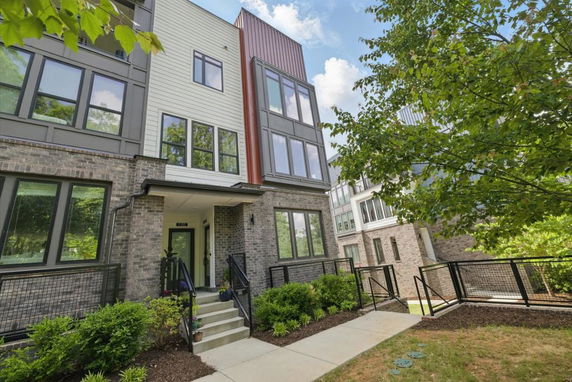 Front view of a multi-story building with a combination of brick and siding exterior.