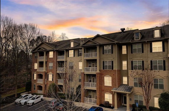 Front view of a multi-story apartment building with balconies.