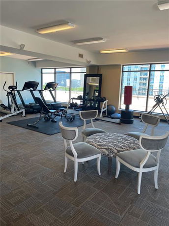Indoor gym area with exercise equipment and seating in a building.