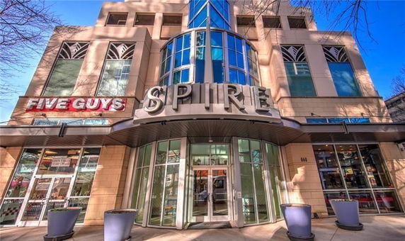 Front view of a modern multi-story building with large glass windows and a prominent 'Spire' sign.