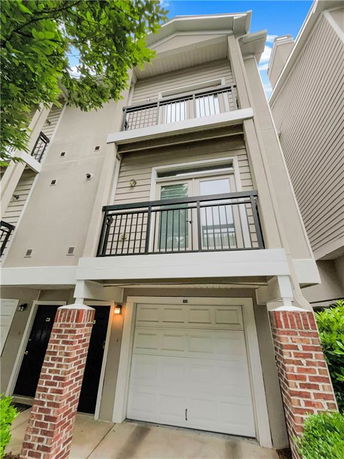 Front view of a multi-story house with a garage and balconies.