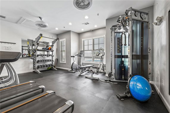 Indoor gym area with exercise equipment including treadmills, weight rack, and strength training machines.