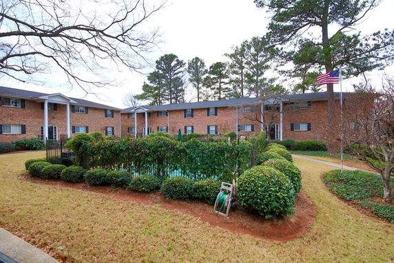 Front view of a two-story brick apartment building with columns and multiple entrances.
