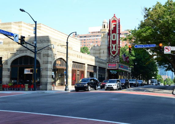 Front view of a historic building with a large vertical sign reading 'FOX' on a busy street corner.