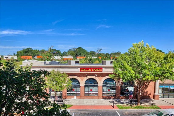 Front view of a commercial building with arched windows and a Wells Fargo sign.