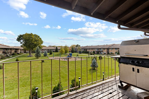 View from a balcony overlooking a courtyard with grass and a playground.