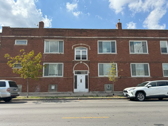 Front view of a two-story brick building with multiple windows and a central entrance.