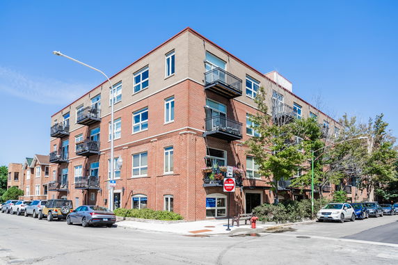Front view of a multi-story brick building with balconies.