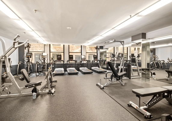 Indoor gym area with various exercise equipment and treadmills.
