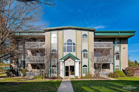 Front view of a multi-story building with green and white accents.