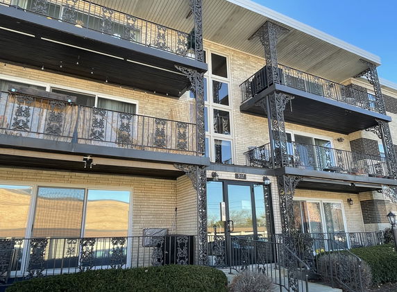 Front view of a multi-story building with decorative railings and balconies.