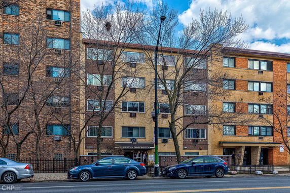Front view of a multi-story residential building with brick facade.